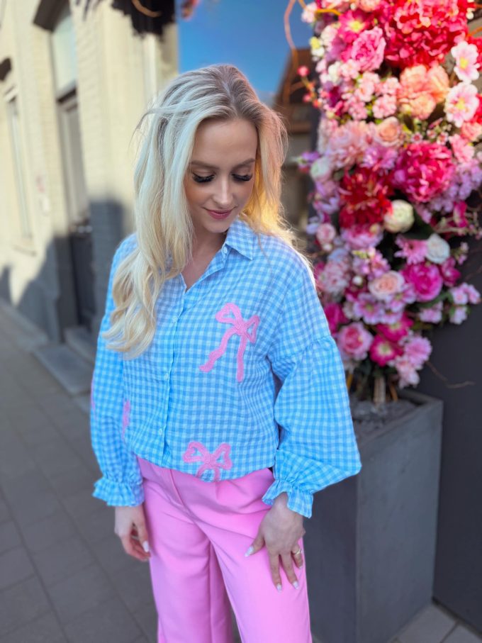 Geruit bloesje met roze strikjes.
