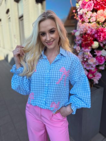Geruit bloesje met roze strikjes.
