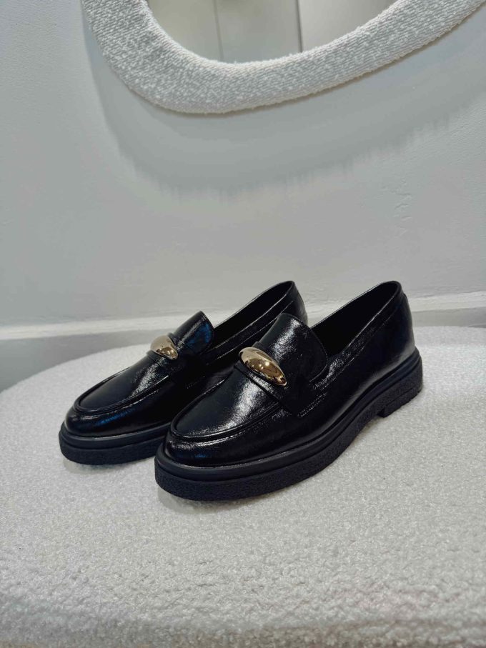 Black mocassin with golden detail.