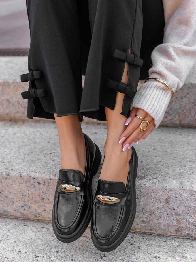 Black mocassin with golden detail.